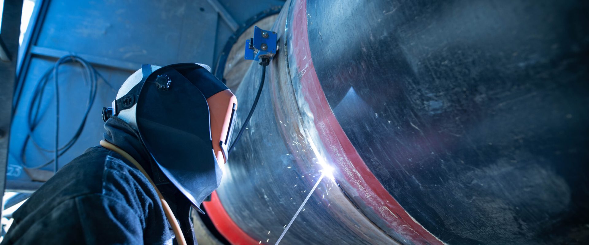 Professional welder welding pipe on a pipeline construction.